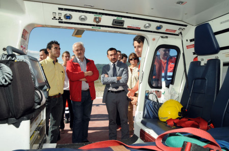 Los representantes de las administraciones observan el interior de un helicóptero de los servicios de emergencia.