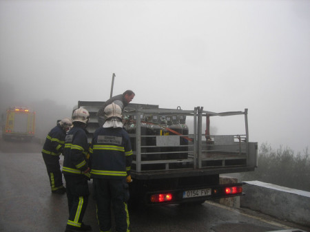 Los bomberos ayudan a reponer la carga en el camión.