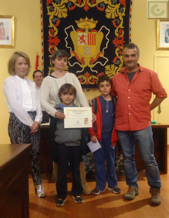 Carmen Montesdeoca y David Menacho, con sus hijos, reciben el primer premio de manos de la concejal Remedios González.