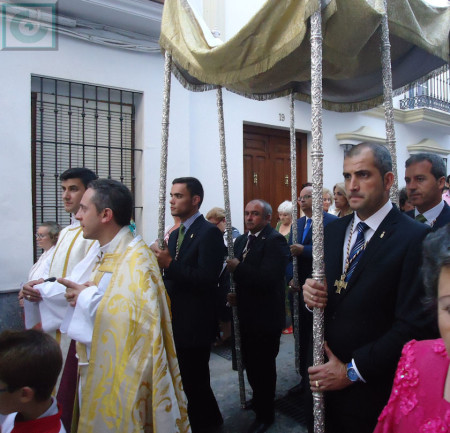Los sacerdotes y miembros de la hermandad, con el palio.