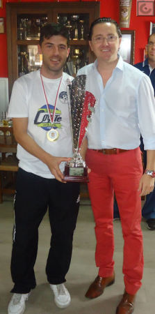 El capitán del Estudiantes, José Antonio Bohórquez, con el trofeo de campeón, y el presidente de la Peña Sevillista, Juan Luis Ríos.