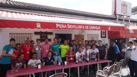 Los campeones y subcampeones, con sus trofeos, ante la fachada del local de laPeña Sevillista.