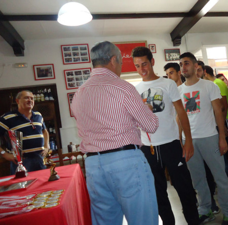 El directivo Miguel Bautista entrega las medallas a lo sjugadores del equipo campeón.