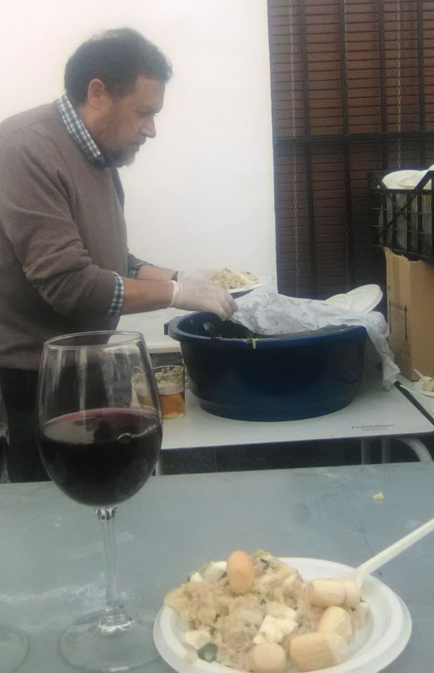 El socio Juan Manuel Román, en la tarea de distribución de platos de papas aliñás.